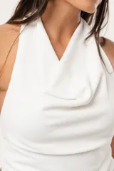 Top blanco de cuello volcado, confeccionado en tejido de punto suave y adaptable.