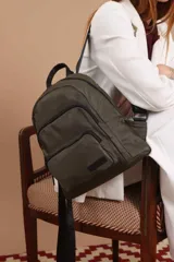 Mochila funcional color beige con detalles en negro, que incluye dos compartimentos con cierre y un bolsillo frontal para fácil acceso.