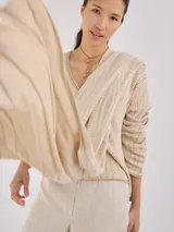 Chal color beige con diseño jacquard, de forma rectangular y caída fluida.