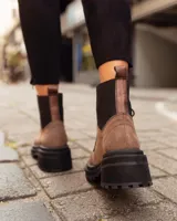 Borcego de gamuza color verde militar con elásticos laterales negros, cordones negros y suela de goma negra con plataforma.