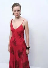 Vestido midi rojo con estampado floral, tirantes finos asimétricos, escote en pico, bajo asimétrico y abertura lateral.