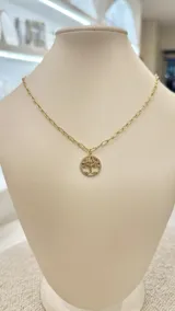 Collar dorado con cadena de eslabones y dije circular con diseño de árbol de la vida con incrustaciones de strass de colores.