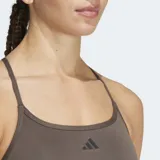 Sostén deportivo Adidas de soporte ligero, color verde oliva, con tiras delgadas ajustables en la espalda y logo pequeño en el frente. Cuenta con almohadillas removibles.