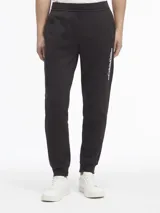 Pantalón de jogging negro con cintura elástica, bolsillos laterales y logo de Calvin Klein estampado en blanco en la pierna derecha.