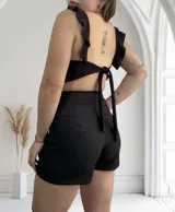 Short pollera negro de corte sastrero con lazo lateral y hebilla metálica.