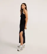 Vestido midi negro ajustado al cuerpo, confeccionado en tejido rib de viscosa. Presenta un diseño asimétrico con un solo hombro descubierto y un bretel con viés contrastante blanco en el escote. Posee un tajo lateral pronunciado.