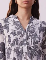 Blusa de gasa estampada con cuello a la base, escote en V y botones. Delantera con detalle plisado y largo de manga regulable con presilla y botón.