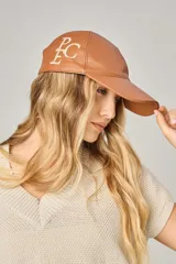 Gorra de cuero color marrón con visera curva y bordado de letras en el frente.