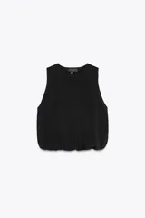 Top negro de punto con cuello redondo y sisa. El bajo es abullonado con elástico interior.
