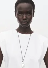 Camiseta blanca de manga corta con hombreras y cuello redondo, de corte recto.