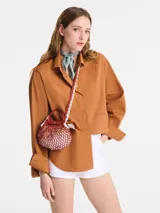 Bandolera Longchamp modelo Le Pliage Xtra Filet Craft XS, color marrón con red de hilo color crudo, asa corta y correa larga de cuero marrón. Cierre con broche a presión.