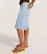 Bermuda tipo jorts de jeans, tiro medio/alto, color celeste claro lavado, corte ancho y largo que llega por encima de la rodilla. Presenta cinco bolsillos y trabillas para cinturón.
