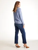 Polera tejida en hilado fino color verde oscuro, de manga larga con tajo en el puño y cuello alto.