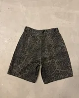 Bermuda de jean tiro alto, corte recto y largo hasta la rodilla, con estampado animal print de leopardo en tonos verde militar y negro.