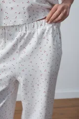 Conjunto de pijama blanco con estampado de lunares rojos, compuesto por una remera de mangas cortas y un pantalón palazzo.