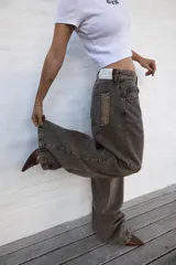 Jean de mujer color gris con efecto acid wash, de corte recto y tiro alto. Incluye bolsillos traseros y etiqueta de marca blanca en la cintura.