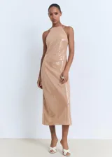 Vestido midi color beige, con diseño recto y escote halter con cierre de lazo en la espalda. El tejido principal es de lentejuelas.