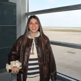 Campera marrón de cuero con botones dorados, bolsillos laterales y corte holgado.