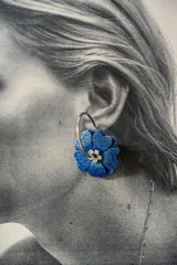 Aros de acero con forma de flor color azul con glitter y centro dorado con strass. Diseño 2en1 con doble flor de distinto color en cada lado.