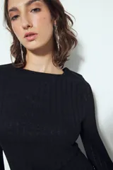 Vestido corto de manga larga acampanada, color marrón óxido, con textura acanalada y terminación ondulada en el ruedo.