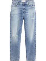 Jean de denim celeste con efecto desgastado y roturas, de corte mom, tiro alto y cinco bolsillos.