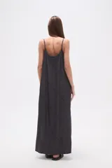 Vestido largo de lyocell, color gris oscuro con efecto lavado, de corte holgado y tirantes finos. Presenta costuras diagonales que crean paneles en la tela.