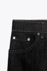 Jeans de tiro alto color marrón, corte slim fit y bootcut, con cinco bolsillos y cierre frontal con cremallera y botón.