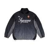 Campera negra con degradado a gris, de cuello alto y cierre frontal con cremallera. Presenta logos de Supreme y Umbro en el pecho, y detalles en gris en mangas y laterales.