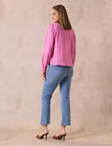Chaqueta color beige de lino y rayón, con cuello mao, cierre frontal con botones y bolsillos delanteros.