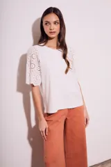 Remera blanca de algodón peinado con calce oversize y mangas cortas con detalle de calados.