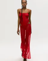 Conjunto de lencería rojo transparente, compuesto por un body con breteles finos y una falda larga de red con abertura lateral.