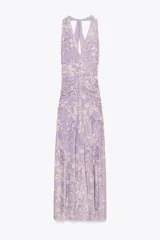 Vestido largo de tul color lila con estampado de flores blancas, cuello halter con lazada y escote pico.