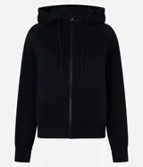 Saco negro de algodón con felpa, con capucha ajustable mediante cordón, mangas largas, cierre delantero de cremallera y bolsillos funcionales.