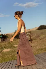 Falda larga de jean color marrón gastado, con corte en el centro y bolsillos delanteros y traseros.