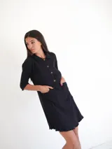 Vestido camisero verde seco de corte holgado, con cuello camisero, mangas 3/4 y cierre frontal con botones.