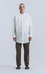 Camisa blanca de manga larga con bolsillo en el pecho, de calce oversize confeccionada en textil fresco y liviano.