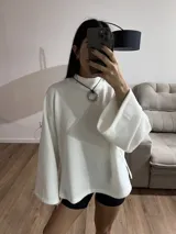 Sweater blanco de tela Aspen, cuello alto y mangas largas con puños acampanados.