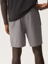 Short deportivo azul con cintura elástica y logo pequeño en la pierna.