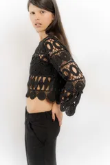 Blusa beige de hilo calado con mangas largas y cuello redondo.