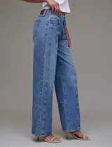 Jean de tiro alto de calce relajado, color azul denim. Tiene pretina con pasadores, botón y cierre. Delantera y trasera con bolsillos. Recortes verticales en el frente y recorte horizontal en el ruedo.