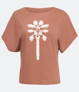 Blusa color marrón claro estilo t-shirt, con cuello redondo y mangas cortas. Presenta un bordado de cocotero en el frente.