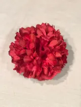 Flor de tela roja con broche francés para sujetar al pelo.