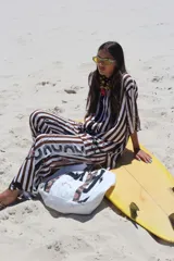 Pantalón largo de corte recto, color crudo con rayas verticales en negro.