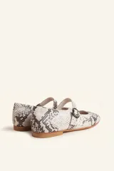 Zapato tipo Mary Jane color borgoña, de charol con correa sobre el empeine y hebilla redonda.