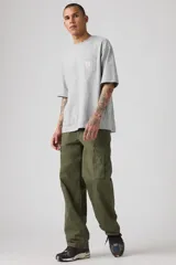 Pantalón cargo verde militar, de corte holgado, con bolsillos laterales con solapa y bolsillos traseros.