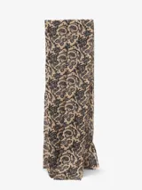 Bufanda rectangular color beige con estampado floral en negro y flecos pequeños en los extremos.