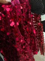 Vestido corto de fiesta color fucsia, con lentejuelas de distintos tamaños, forrado en su interior de color rojizo, con tirantes finos elastizados y cierre invisible en la espalda.