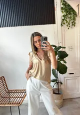 Blusa dorada con escote en V y mangas cortas con volados.