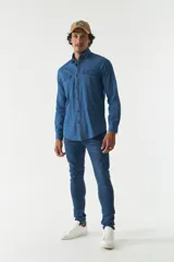 Camisa de jean azul de manga larga con dos bolsillos frontales con solapa abotonada.