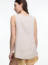 Top sin mangas color beige, confeccionado en lino, con escote en V y calce amplio. Presenta laterales en color blanco.